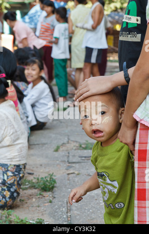 Ragazzino con tradizionale crema Thanaka sul suo volto a Rangoon, Myanmar Foto Stock