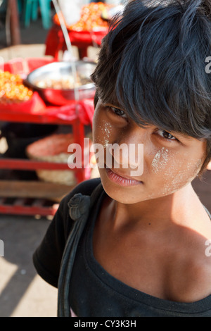 Ragazzino con tradizionale crema Thanaka sul suo volto a Rangoon, Myanmar Foto Stock