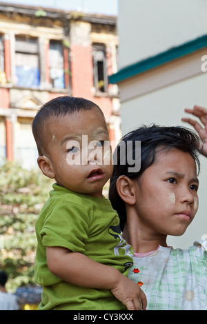 Ragazzino con tradizionale crema Thanaka sul suo volto a Rangoon, Myanmar Foto Stock