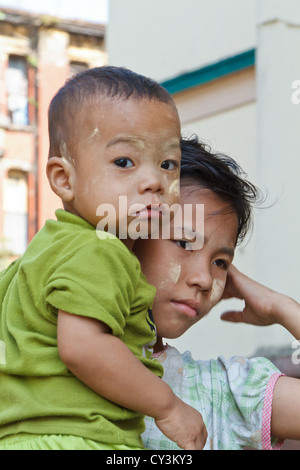 Ragazzino con tradizionale crema Thanaka sul suo volto a Rangoon, Myanmar Foto Stock