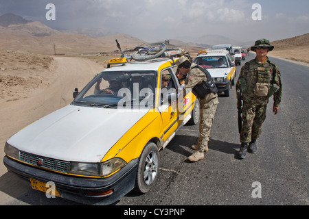 La polizia afghana e checkpoint militare alla ricerca di sospetti terroristi, appena outide maidaïen città. Foto Stock