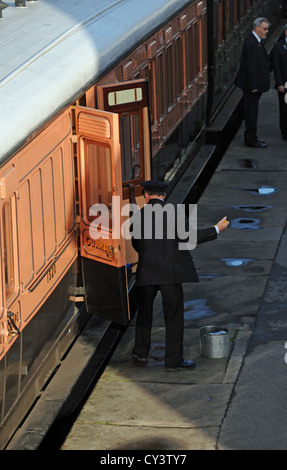 Appassionato di rampa di pulizia della piattaforma e carrozze ferroviarie a Sheffield Park Station sulla linea Bluebell SUSSEX REGNO UNITO Foto Stock