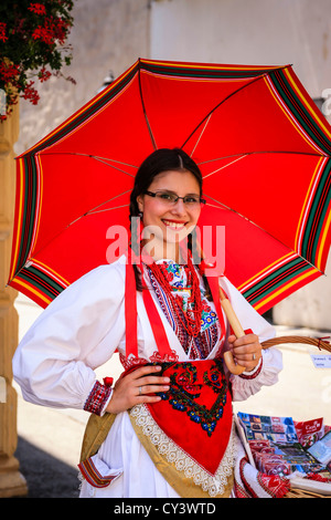 Il croato ragazza vestita in abiti tradizionali di vendita di souvenir in Zagreb Foto Stock