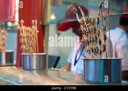 Spiedini di scorpioni e mare i cavalli in vendita presso la Donghuamen Night Market, su Via Wangfujing di Pechino, Cina. Foto Stock