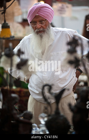 Un uomo Sikh accede in una fase di stallo nel Spitalfields Market, London, Regno Unito Foto Stock