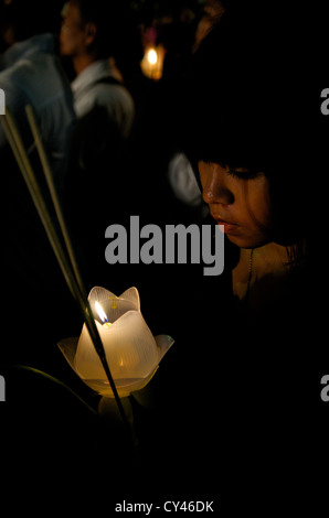 Giovane ragazza tailandese che prega con candela e incenso il giorno del Buddha, Wat Saket, Phu Khao Thong (montagna dorata), Bangkok, Thailandia. Maggio 2011. © Kraig Lieb Foto Stock