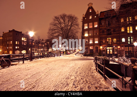 Cityscenic da Amsterdam coperte di neve nei Paesi Bassi durante la notte Foto Stock