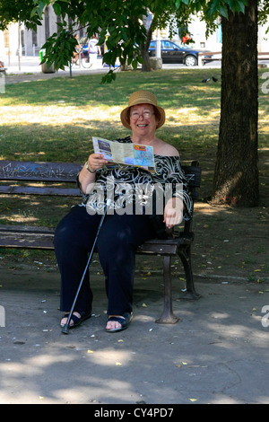 Senior turista femminile a Budapest Leggi la sua guida come ella tours la città Foto Stock