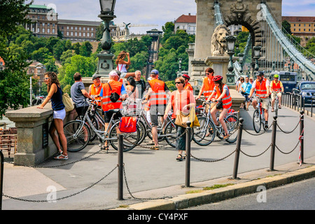 Un gruppo ciclistico in Budapest tutti indossano Hi-Vis giubbotti di arancione Foto Stock