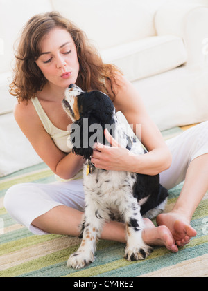 Ritratto di giovane donna che gioca con il cane Foto Stock