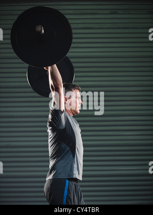 Stati Uniti, California, Laguna Niguel, uomo maturo il sollevamento di un carico pesante barbell Foto Stock