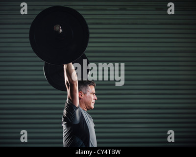 Stati Uniti, California, Laguna Niguel, uomo maturo il sollevamento di un carico pesante barbell Foto Stock