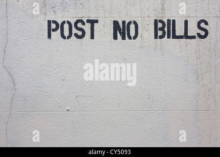 Rimosso graffiti e 'Post le fatture non' stencil pulito sul muro bianco nel central London street. Foto Stock