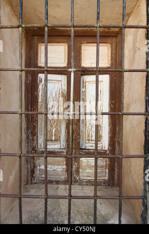Vecchia finestra in legno con barre di ferro nero Foto Stock