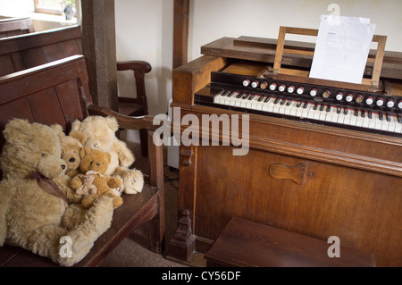 Organo da chiesa con orsetti di peluche seduto su un pew a Capel y Ffin nel Parco Nazionale di Brecon Beacons Wales UK cappella interna Foto Stock