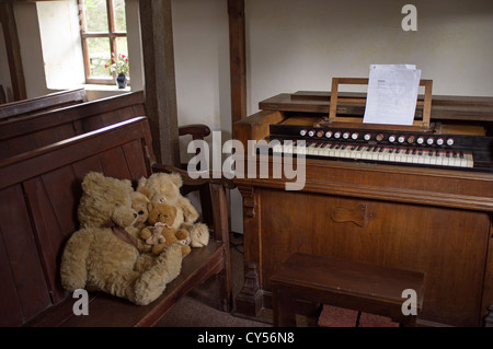 Organo da chiesa con orsetti di peluche seduto su un pew a Capel y Ffin nel Parco Nazionale di Brecon Beacons Wales UK cappella interna Foto Stock