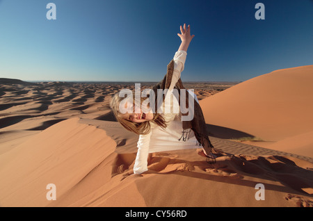 Ragazza giovane giocando in dune del Sahara in Marocco Foto Stock