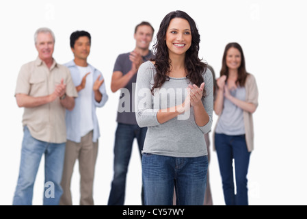 Clapping giovane donna con gli amici dietro di lei Foto Stock