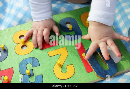 Un bambino che gioca con un numero puzzle. Foto Stock