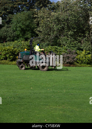 Uomo in hi vis jacket alla guida di una grande corsa sul tosaerba in consiglio il Park Sheffield South Yorkshire Inghilterra Foto Stock