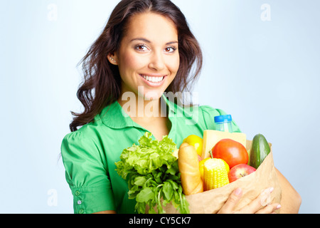 Ritratto di bella ragazza con un grande sacco carta piena di diversi tipi di frutta e verdura in isolamento Foto Stock