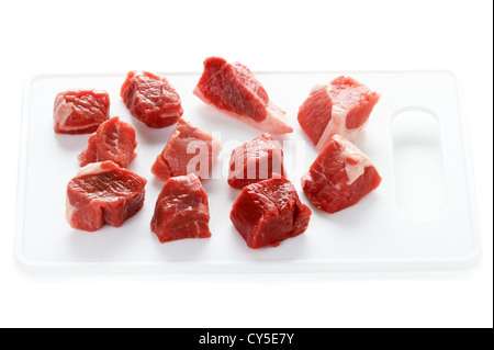 Tagliate a dadini materie carne di agnello tagliato a cubetti isolati su sfondo bianco Foto Stock