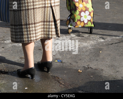 Vecchia donna con carrello di shopping in strada in città Foto Stock