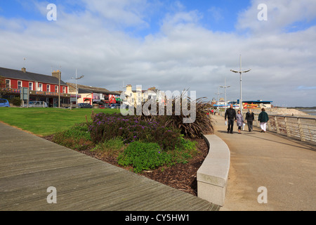 La gente che camminava sul lungomare della località balneare sulla costa est a Newcastle, Co Down, Irlanda del Nord, Regno Unito Foto Stock
