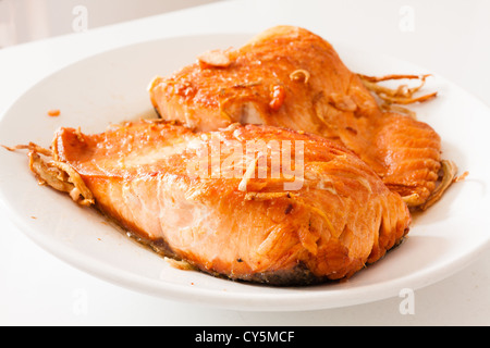 Scottato in padella, Carne saltata cileno di filetto di salmone con zenzero su piastra bianca sullo sfondo Foto Stock