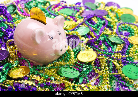 Mardi Gras piggy pank su una pila di Mardi Gras perle e monete Foto Stock