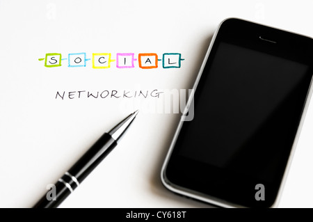 Social Networking concetto con lettere colorate, moderno touch screen mobile phone e penna a sfera Foto Stock