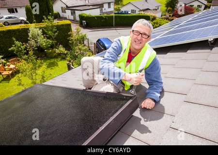 Solare pannelli fotovoltaici su un tetto di casa a Ambleside, Lake District, UK, con energia solare termica, acqua pannelli di riscaldamento. Foto Stock