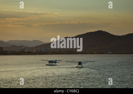 Due piani di flottazione nel porto di Cairns Australia presso sunrise - una preparazione per il decollo Foto Stock