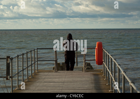 Lo straniero sul pontile, che guarda al mare. Foto Stock