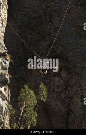 Giovane uomo per divertirsi durante una Zip Line volo In Banos de Agua Santa Ecuador Foto Stock