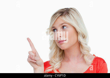 Giovane donna puntando qualcosa in aria con le sue dita Foto Stock
