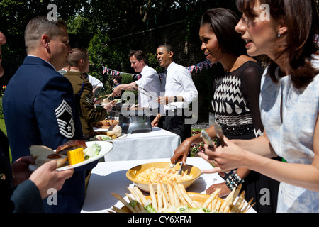Il Presidente Usa Barack Obama, il Primo Ministro britannico David Cameron, First Lady Michelle Obama e Samantha Cameron servire famiglie militari durante un barbecue in giardino a 10 Downing Street 25 Maggio 2011 a Londra, Inghilterra. Foto Stock