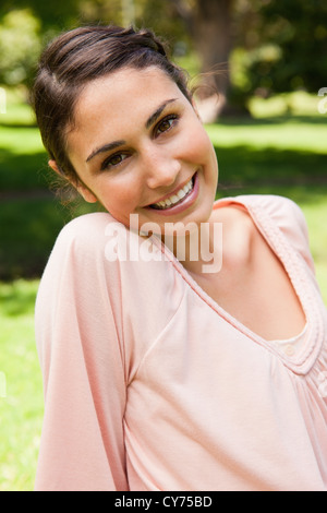 Donna sorridente con la sua testa inclinata verso il lato Foto Stock