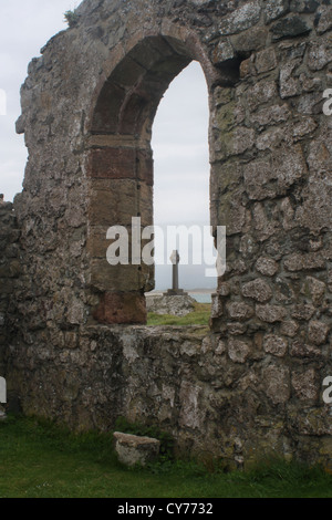 St Dwynwens rovine della chiesa celtica e la croce sulla isola Llandwynn Anglesey Foto Stock