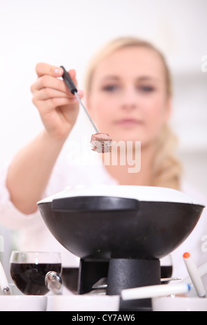 Donna di mangiare una Fondue bourguignonne Foto Stock