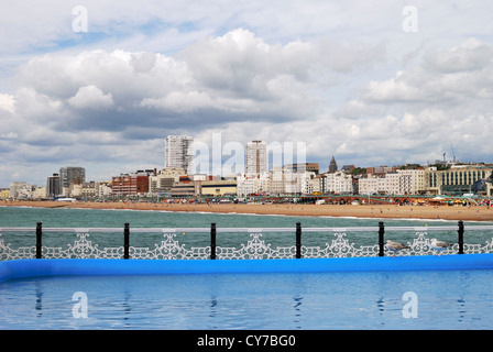 La spiaggia di Brighton e città visto dal molo. East Sussex. In Inghilterra. Con la cortina di nubi e cielo nuvoloso. Foto Stock