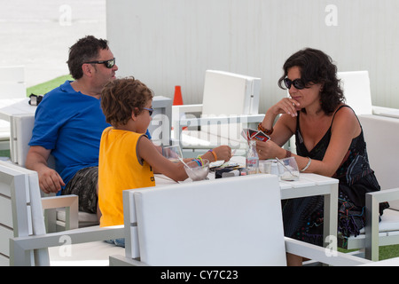 Famiglia giocando a carte presso un ristorante locale. Lungomare di Malaga Spagna Foto Stock