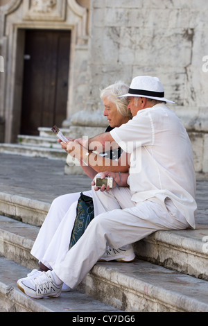 Coppie mature turisti consultano guida, studiando informazioni turistiche. Cadice. Spagna Foto Stock