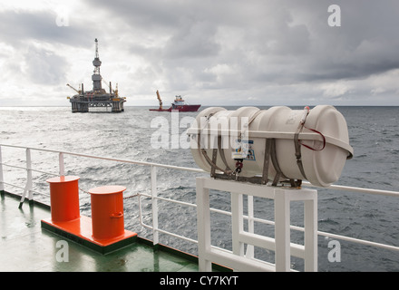 Live zattera con oil rig e rifornitore in background sul Mare del Nord Foto Stock