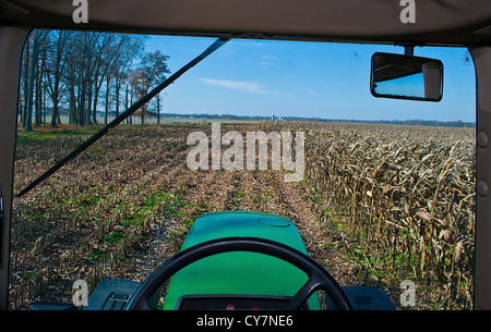 Agricoltore e la vista dalla cabina del trattore nel campo di grano mietuto. Foto Stock