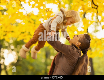 Giovane madre gettando baby fino Foto Stock
