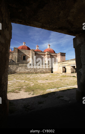 Le cupole e rovine presso la Mitla, Oaxaca, Messico sito archeologico visibile attraverso una finestra. Foto Stock