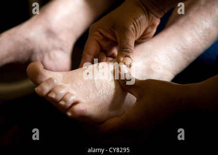 Il piede di una donna anziana di essere massaggiato / piedi Massaggio su un senior / pensionati / donna anziana / a persona. Foto Stock