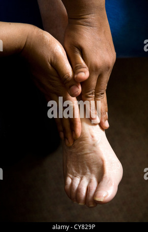 Il piede di una donna anziana di essere massaggiato / piedi Massaggio su un senior / pensionati / donna anziana / a persona. Foto Stock