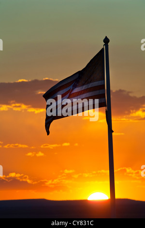 Tramonto dietro la bandiera americana sventolare nel vento vicino a Winslow, Arizona Foto Stock